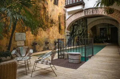 a patio with two chairs and a pool at Hotel Casa La Factoria by Faranda Boutique, a member of Radisson Individuals in Cartagena de Indias