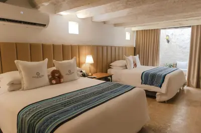 two beds in a hotel room with a teddy bear on them at Hotel Casa La Factoria by Faranda Boutique, a member of Radisson Individuals in Cartagena de Indias