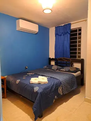 a bedroom with two beds and a blue wall at Hostel Shalom Adonai in Cartagena de Indias