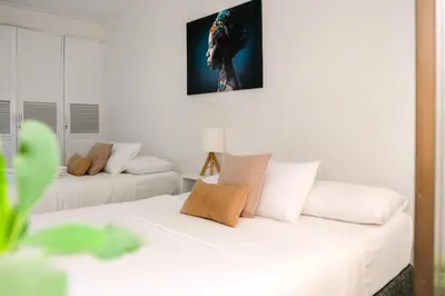 a white room with two beds and a couch at Mucura Hotel & Spa in Cartagena de Indias
