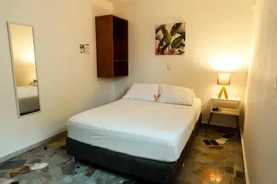a small bedroom with a bed and a mirror at Mucura Hotel & Spa in Cartagena de Indias