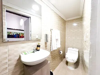 a white bathroom with a sink and a toilet at Hotel AT THE PARK in Cartagena de Indias