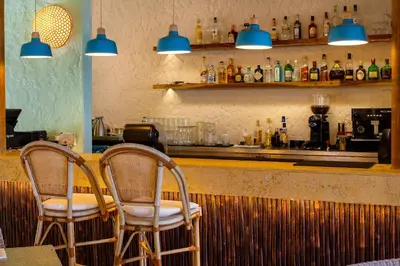 two chairs sitting at a bar with blue lights at Hotel San Pedro de Majagua in Isla Grande