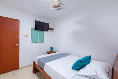 a bedroom with a bed and a tv on the wall at Hotel Nuevo Yalu in Barranquilla