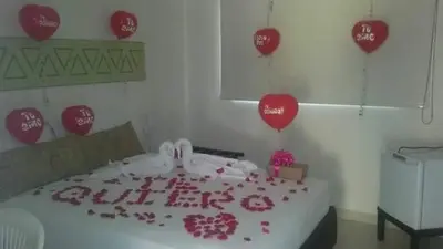 a room with a bed with red hearts and balloons at Terra Toscana Hotel in Mangue
