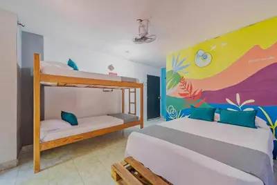 a bedroom with two bunk beds and a colorful wall at Hostal Casa Tropicalia in Barranquilla