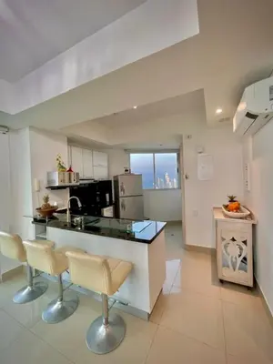 a kitchen with a counter and chairs in a room at Beach front Apartament in Cartagena de Indias