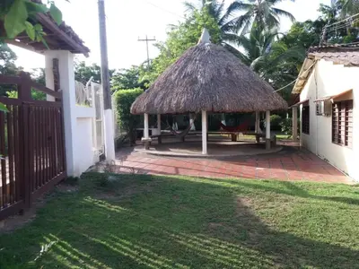 a gazebo with a thatch roof in a yard at Cabaña Coveñas Punta Bolivar in Coveñas