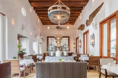 a dining room with tables and chairs and a chandelier at Hotel Casa San Agustin in Cartagena de Indias