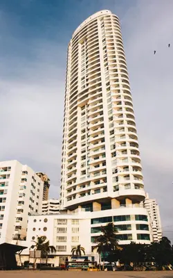 a tall white building with palm trees in front of it at Palmetto Eliptic 4003 in Cartagena de Indias