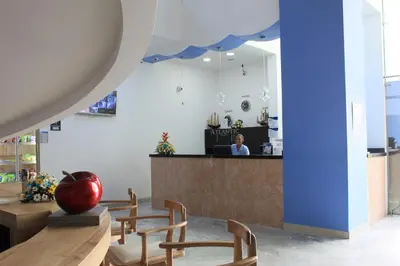 a restaurant with chairs and a counter with a person in the background at Hotel Atlantic Lux in Cartagena de Indias