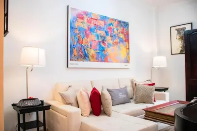 a living room with a white couch and a painting at Casa Fanny in Cartagena de Indias