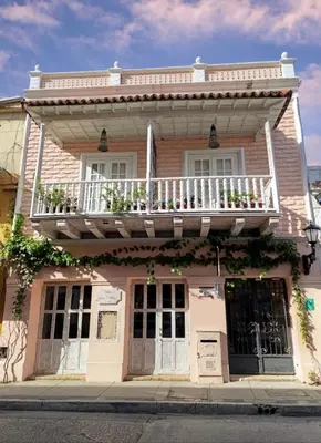 a pink house with a balcony on top of it at Cartagena Legends in Cartagena de Indias