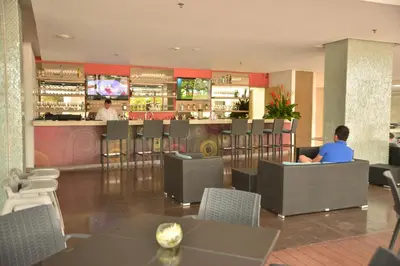a man sitting at a bar in a restaurant at Modern 3 Bedroom Apartment with sea-beach view in Cartagena de Indias