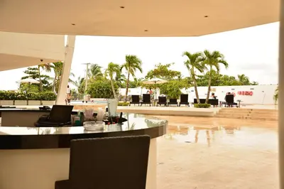 a resort lobby with a bar and tables and palm trees at Modern 3 Bedroom Apartment with sea-beach view in Cartagena de Indias