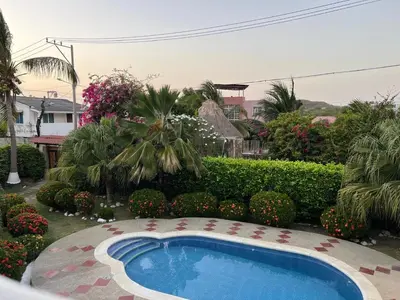 a swimming pool in a yard with bushes and trees at Villa Las Marias in Santa Veronica