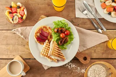a table with two plates of breakfast foods and drinks at Genesis Hotel in Sincelejo