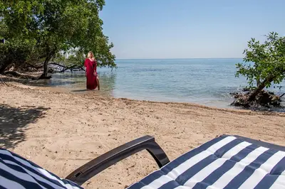 a woman standing in the water on a beach at Isla Tijereto in Isla Grande