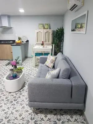 a living room with a gray couch and a kitchen at Casa Anita in Cartagena de Indias