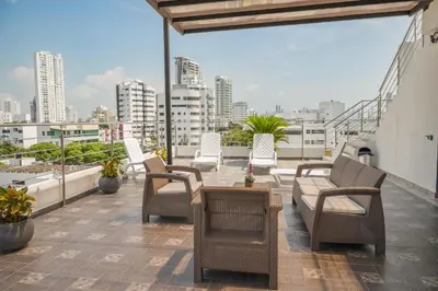 a balcony with chairs and a table on a building at Bahia 79 Apartasuites Cerca al Centro in Cartagena de Indias