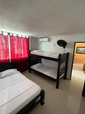 two bunk beds in a room with red curtains at Alojamientos Cartagena Edificio Los Delfines in Cartagena de Indias