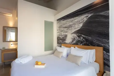 a bedroom with a large bed with a painting on the wall at Delirio Hotel in Cartagena de Indias