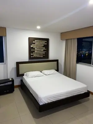 a bedroom with a large bed with white sheets at Palmetto Suite Superior 3901 in Cartagena de Indias