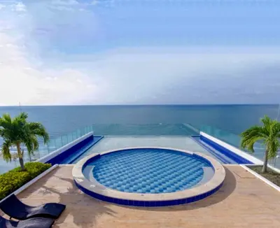a swimming pool with the ocean in the background at Cartagena Beach Front Apartments in Cartagena de Indias