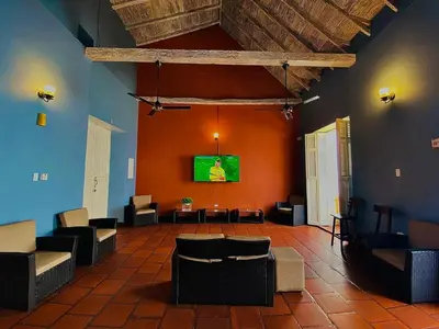 a living room with chairs and a tv on a wall at Hotel El Viajero Centro in Cartagena de Indias