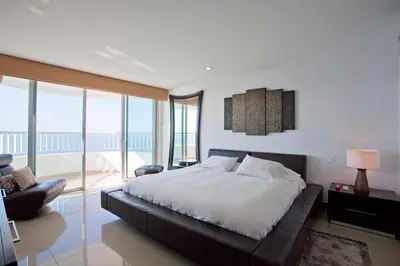 a bedroom with a large bed and a balcony at Palmetto Penthouse Deluxe Beautiful view and sunset floor 39 in Cartagena de Indias