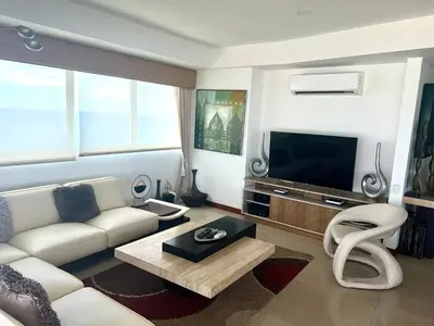 a living room with a white couch and a television at Palmetto Penthouse Deluxe Beautiful view and sunset floor 39 in Cartagena de Indias