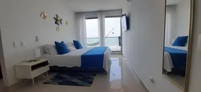 a bedroom with a bed with blue pillows and a mirror at Mi Apartamento en Cartagena in Cartagena de Indias