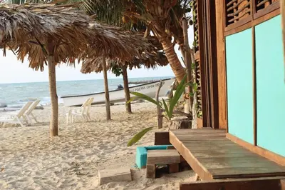 a building on the beach with chairs and the ocean at Casa Akira- Rincón del Mar in San Onofre