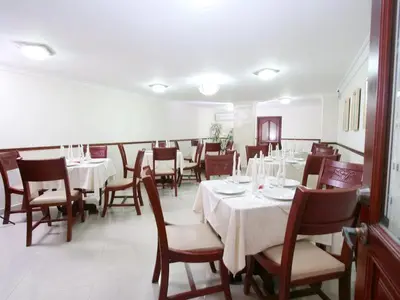a dining room with white tables and chairs at Hotel Intersuites in Barranquilla