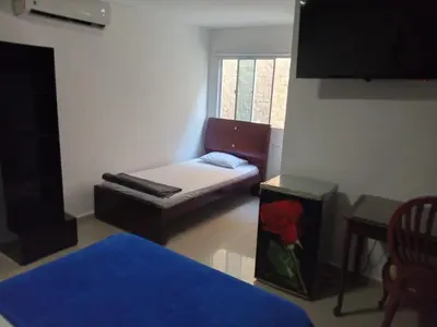 a small room with a couch and a window at Hotel Intersuites in Barranquilla