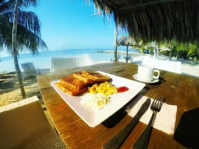 a plate of breakfast food on a table with the beach at MISTICA Isla Palma in Isla Palma