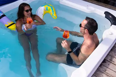 a man and woman in a swimming pool with drinks at Los Patios Hostel Cartagena in Cartagena de Indias