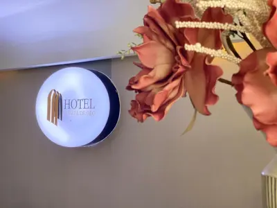 a blue clock on a wall next to a flower at Hotel Puerta de Oro in Barranquilla