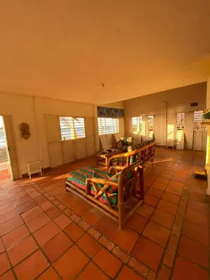 a room with benches and a table and windows at Cabaña Playa De Los Venados in San Bernardo del Viento