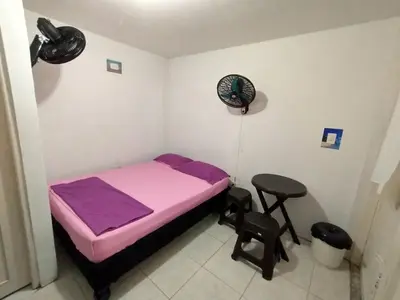 a small bedroom with a purple bed and a stool at Oasis de Tolú in Tolú