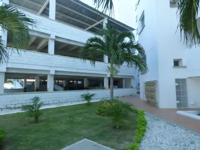 a building with a palm tree in front of it at Costa Azul Suites 905 in Santa Marta