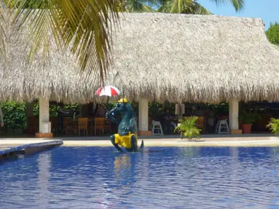 a pool at a resort with a statue in the water at Costa Azul Suites 905 in Santa Marta
