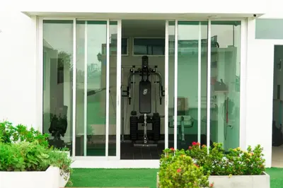 a glass door on a white house with flowers at Hotel Buenos Aires in Cartagena de Indias