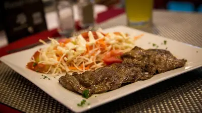 a plate of food with meat and vegetables on a table at Hotel Buenos Aires in Cartagena de Indias