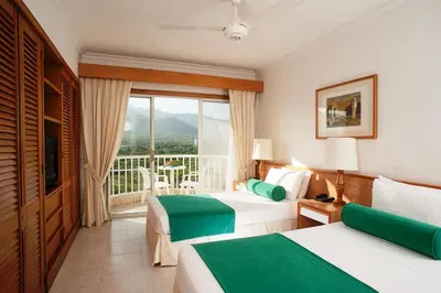 a hotel room with two beds and a balcony at Hotel Irotama XXI in Santa Marta