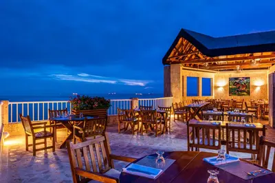 a restaurant with tables and chairs on a balcony at Hotel Irotama XXI in Santa Marta