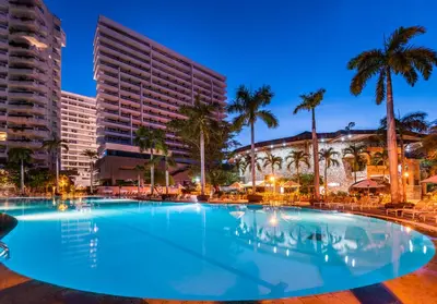a large swimming pool with palm trees and buildings at Hotel Irotama Lago in Santa Marta