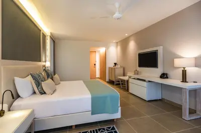 a bedroom with a bed and a desk and a television at Hotel Irotama Lago in Santa Marta