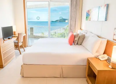 a bedroom with a bed with a view of the ocean at Hotel Irotama del Sol in Santa Marta