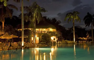 a swimming pool with palm trees and a resort at Hotel Irotama del Mar in Santa Marta